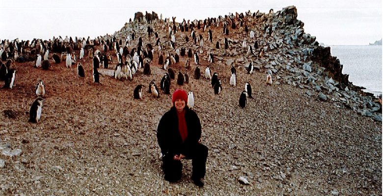 Sandi Davison, PA/Administrator, with Chinstrap Penguins on Half Moon Island, Antarctica